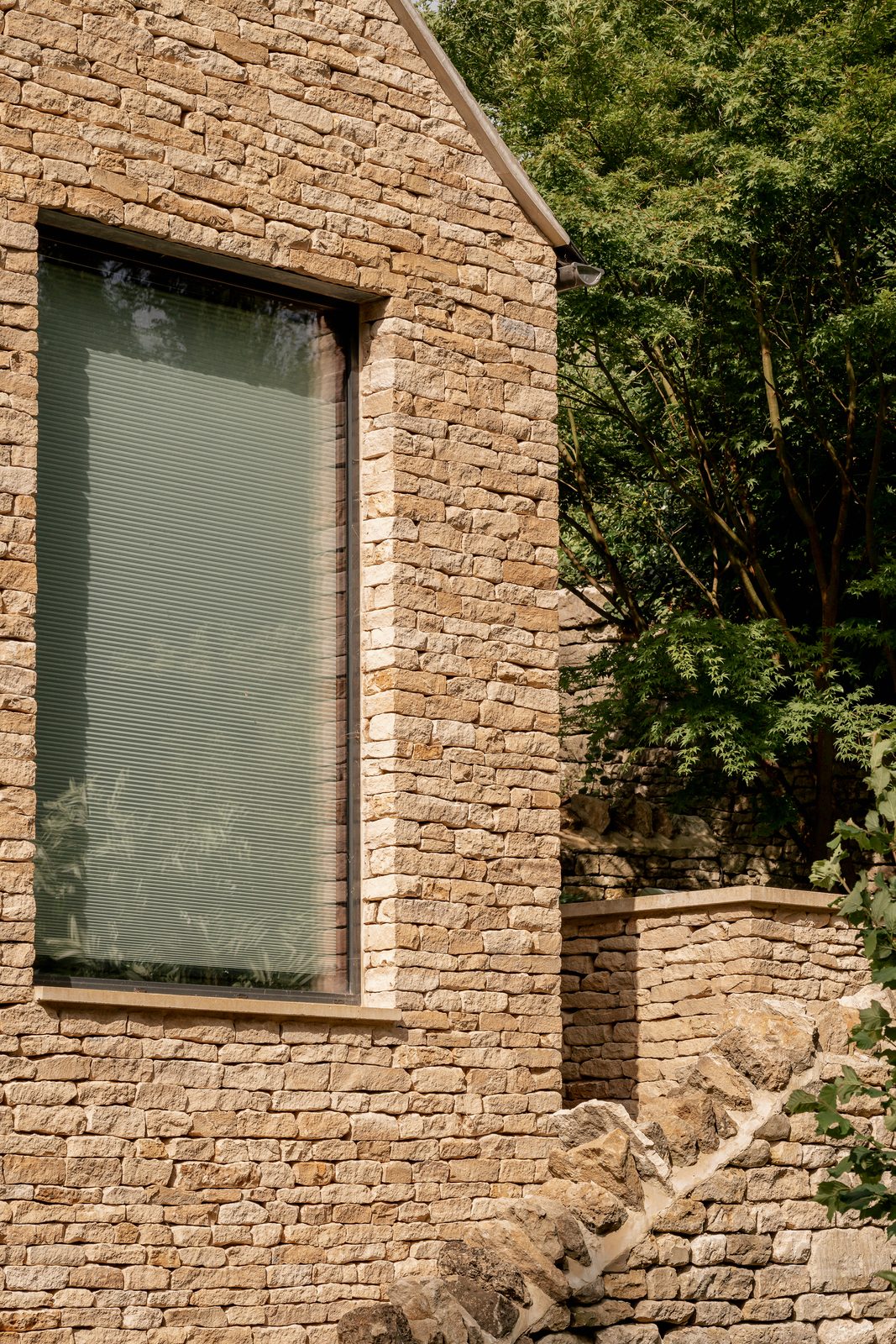 Dry-stone gable of the cottage extension with a deep-set window
